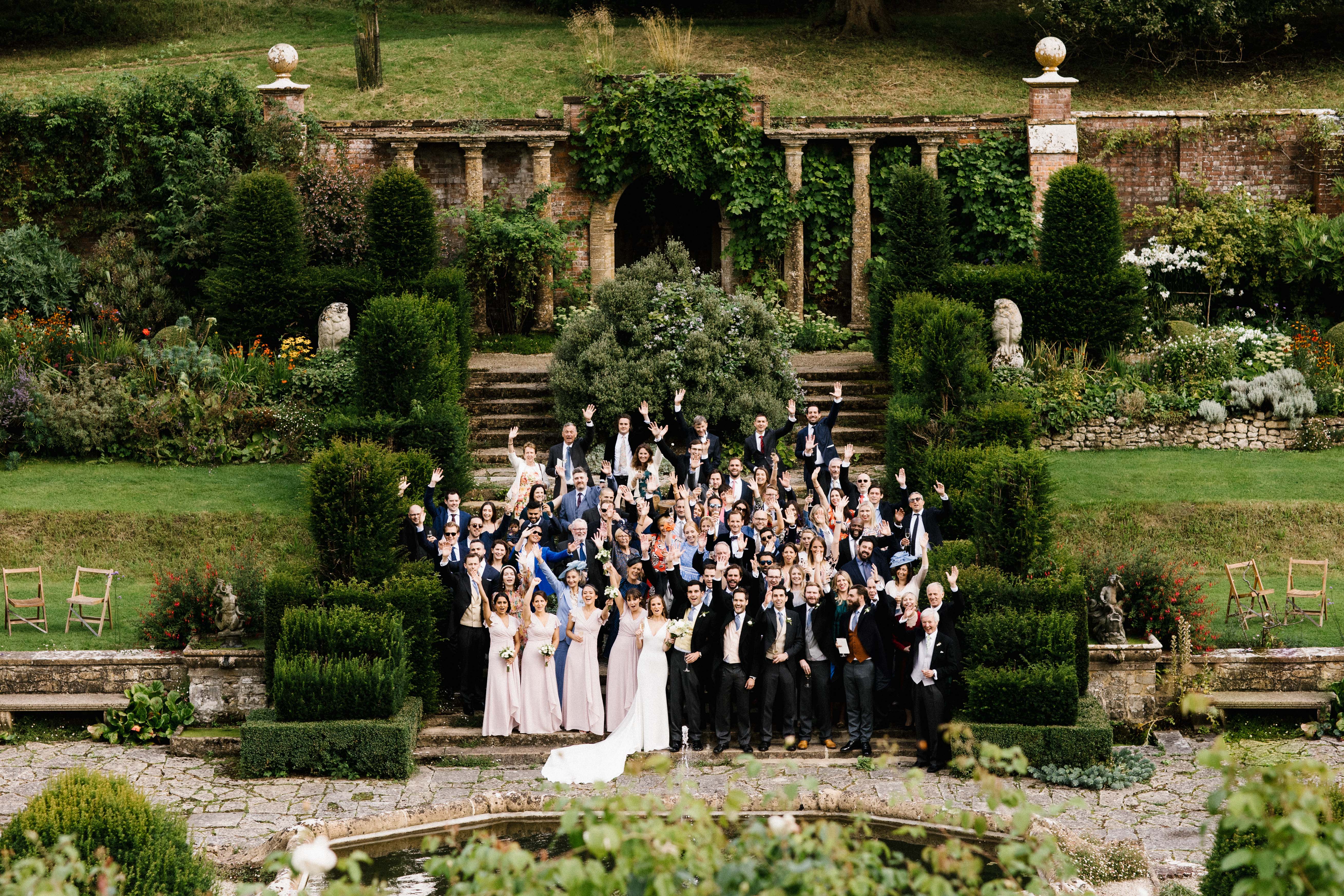 Group photo of wedding guests and couple outside of a south west wedding venue called Mapperton House