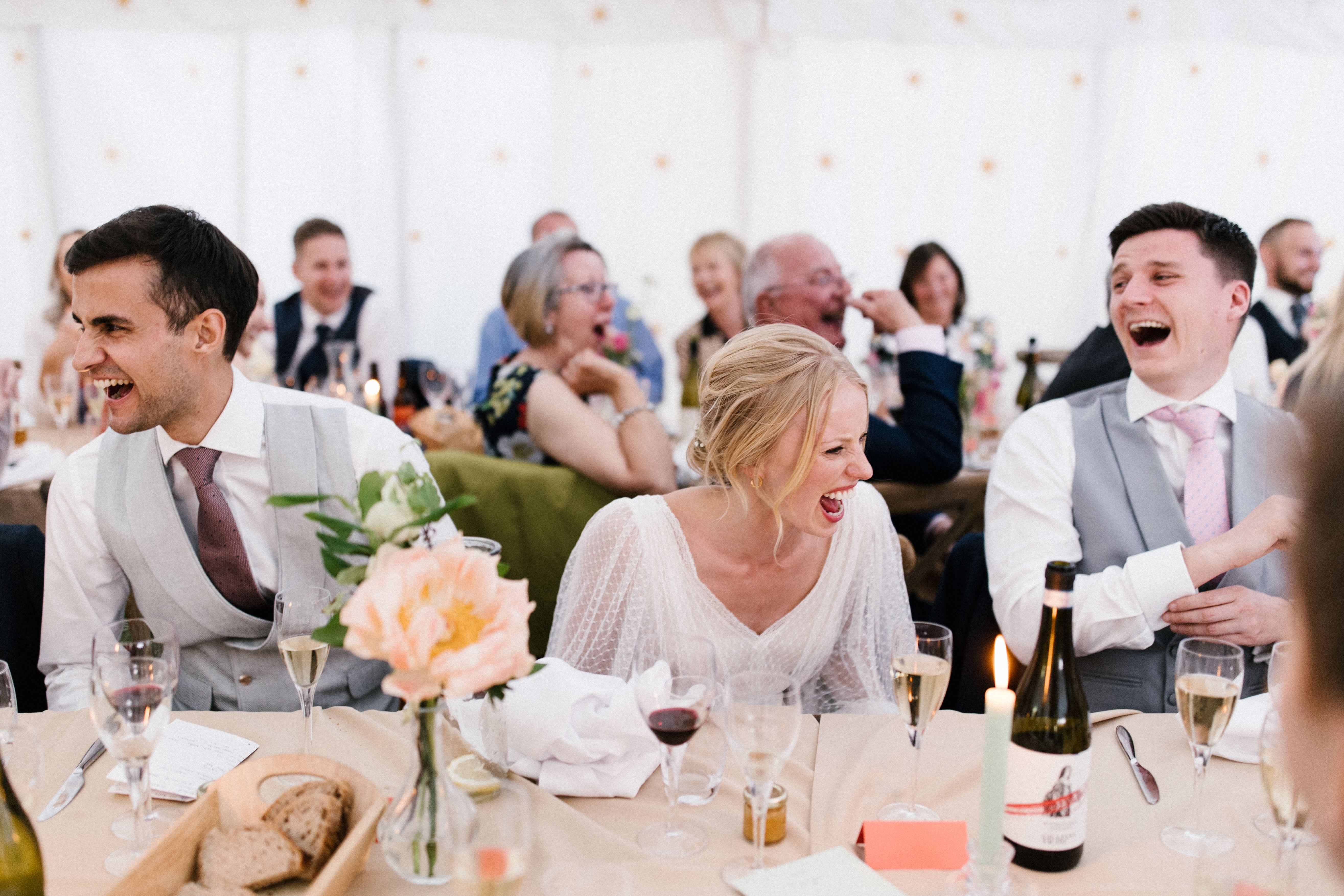 Couple and guests laughing during speeches at a south west wedding venue called Hatch House