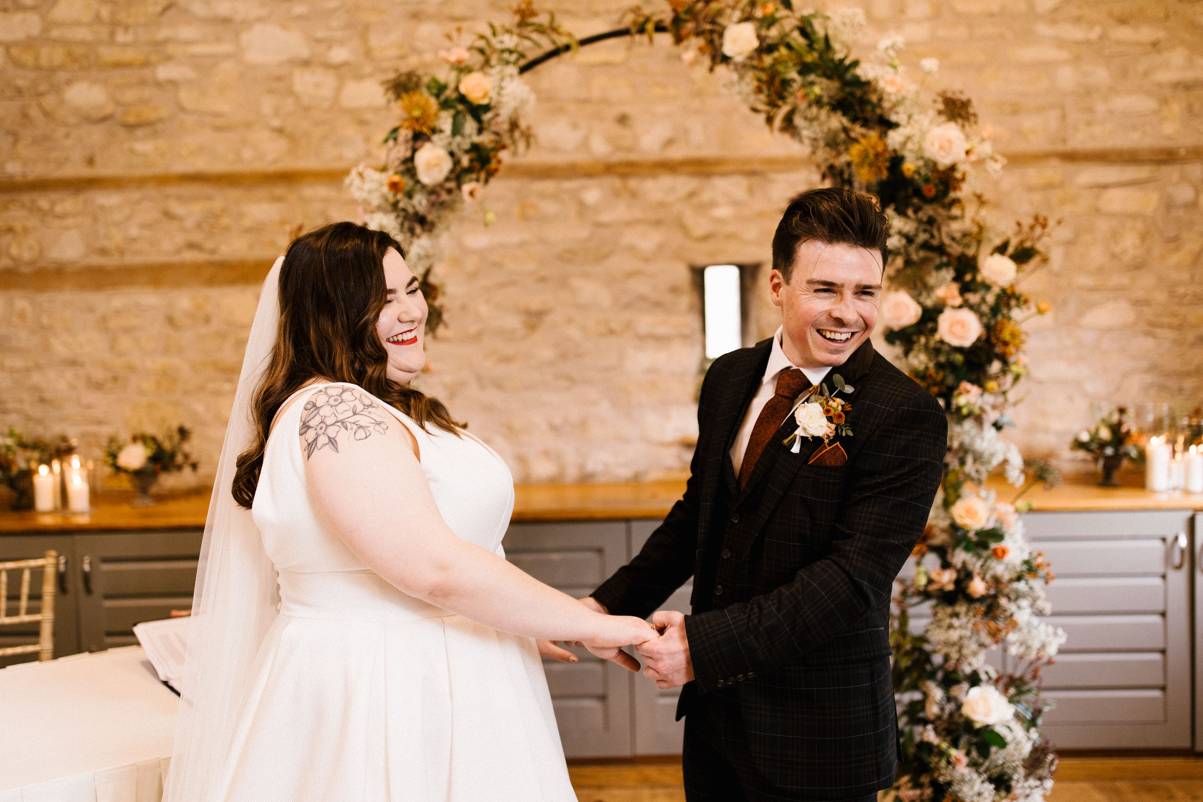 Couple hand in hand and smiling during ceremony at Barn wedding venue called Folly Farm