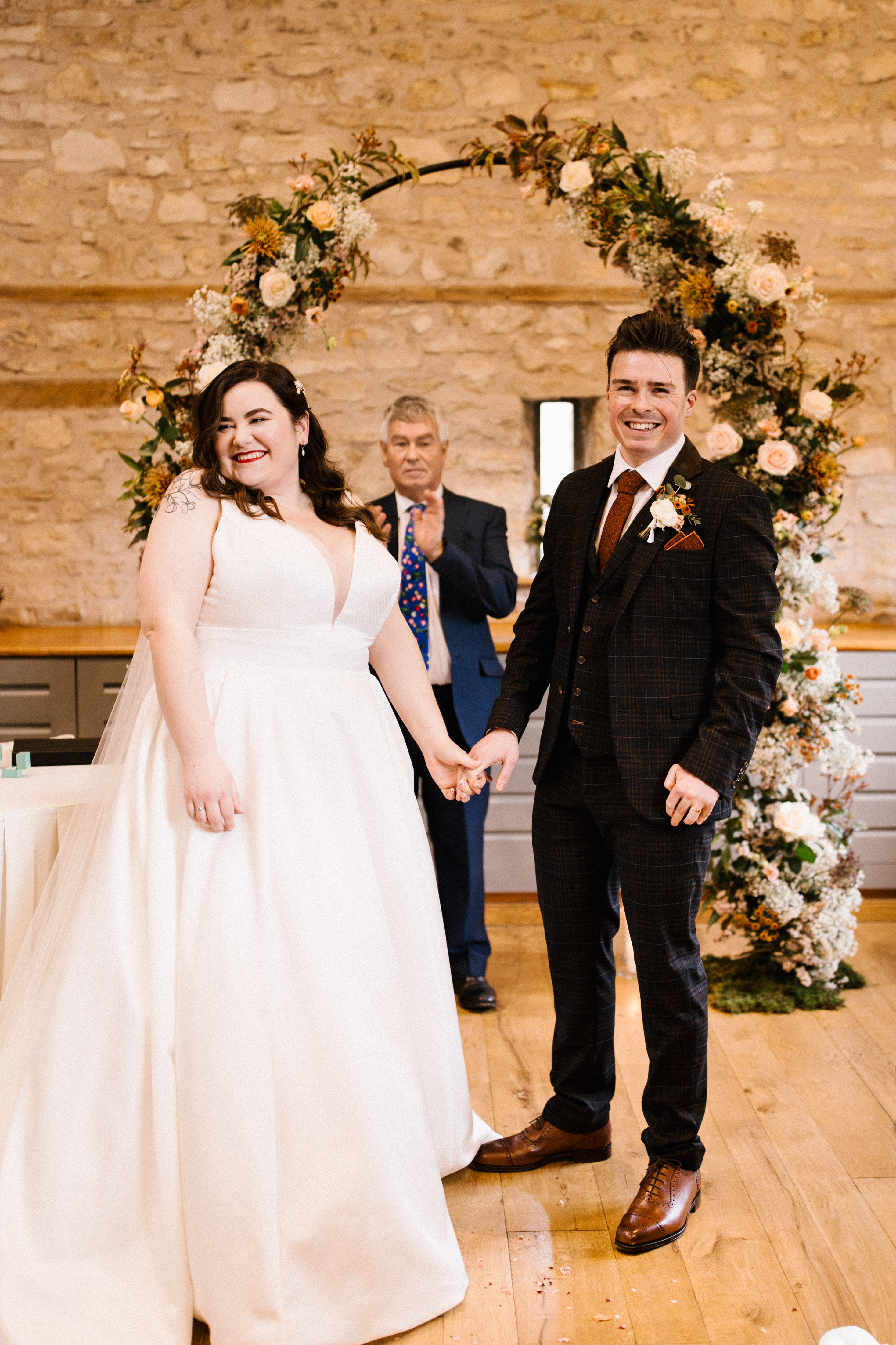 Couple hand in hand and smiling during ceremony at Barn wedding venue called Folly Farm