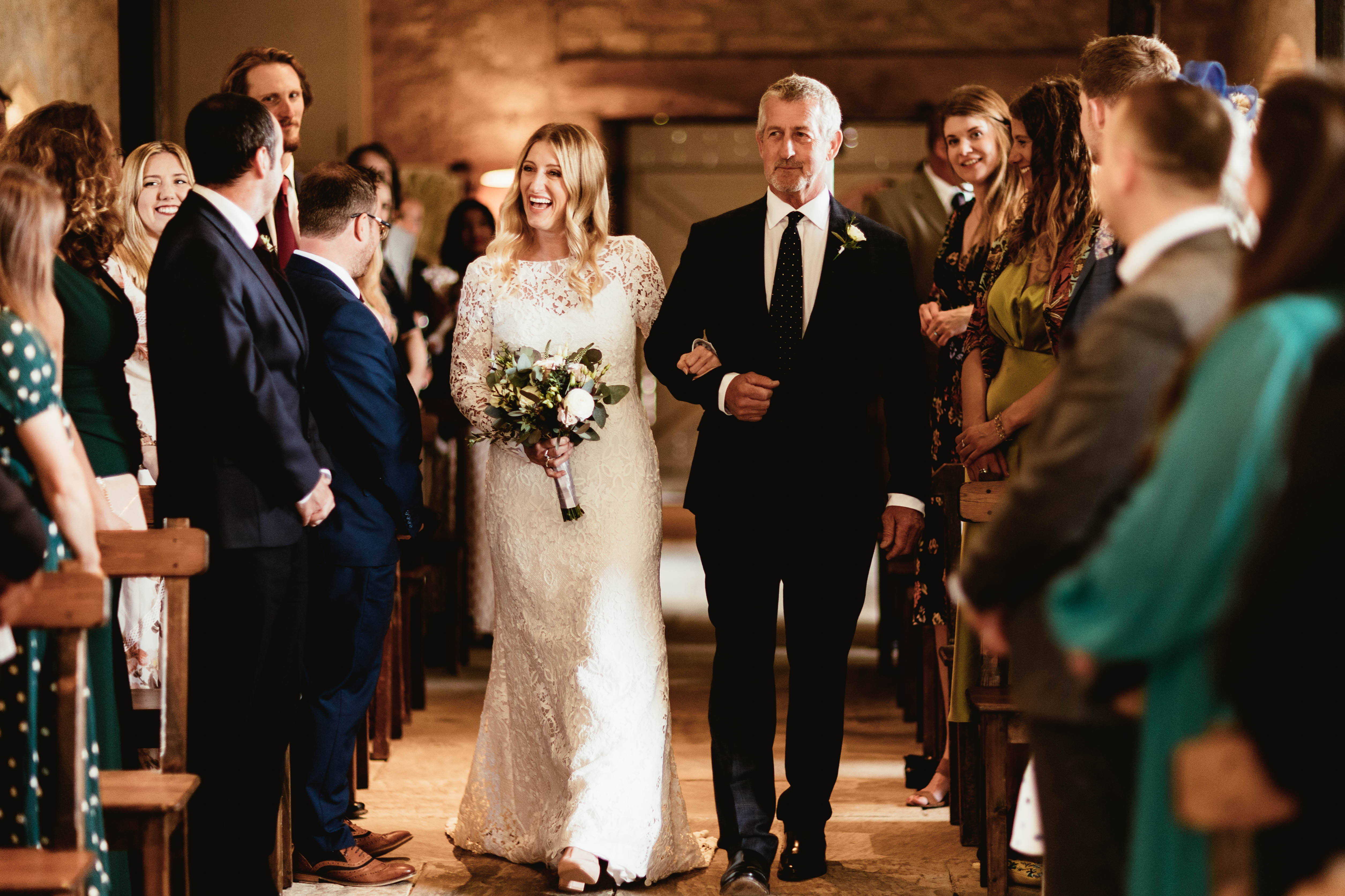Bride walking down the aisle at her wedding venue in the south west called Brympton House