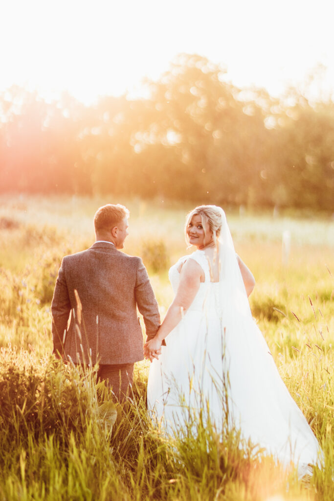 Bride and groom walking outdoors hand in hand at a wedding venue in the south west called Elmore Court 