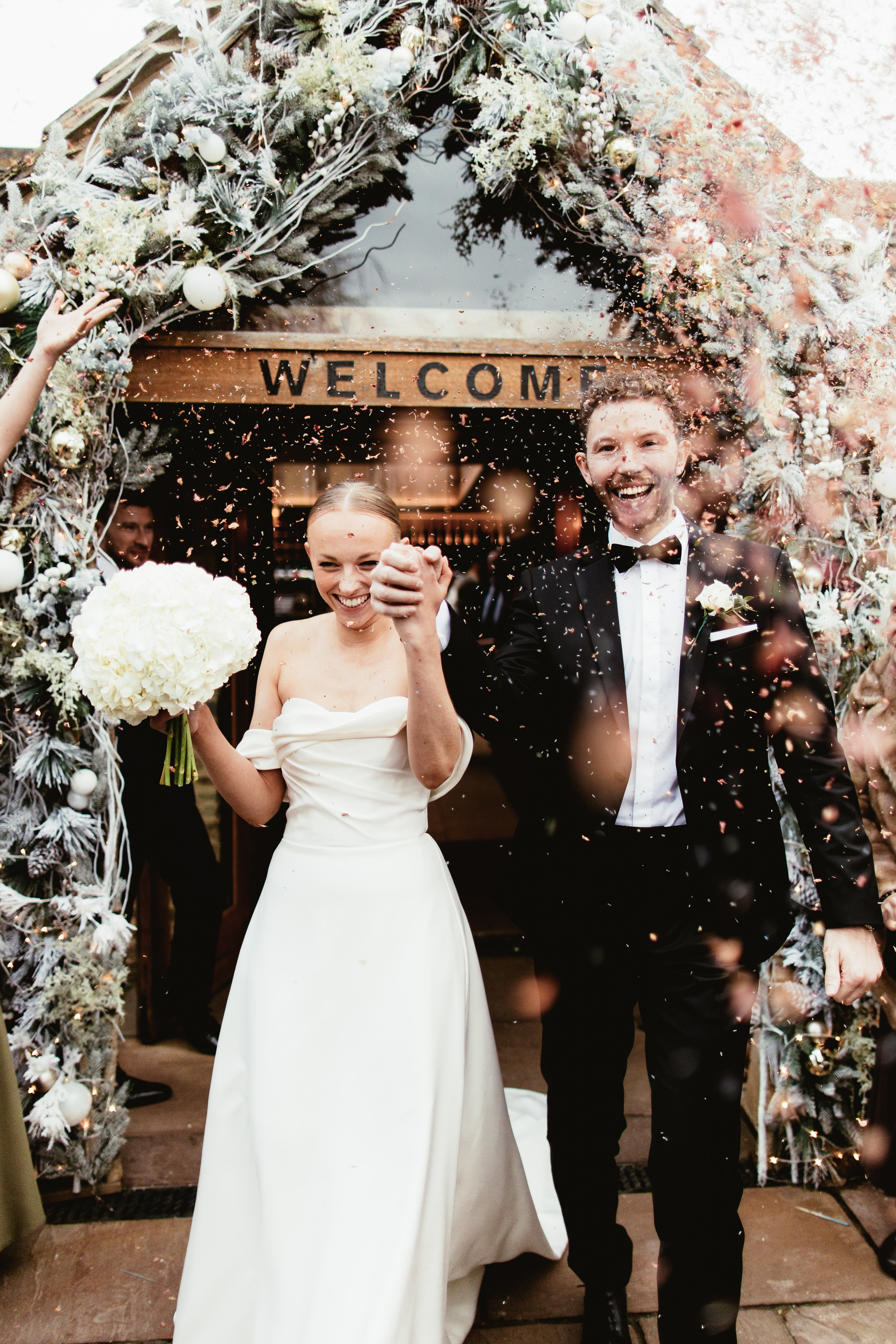 Couple portrait during confetti moment outside of their barn wedding venue called Wild Thyme and Honey